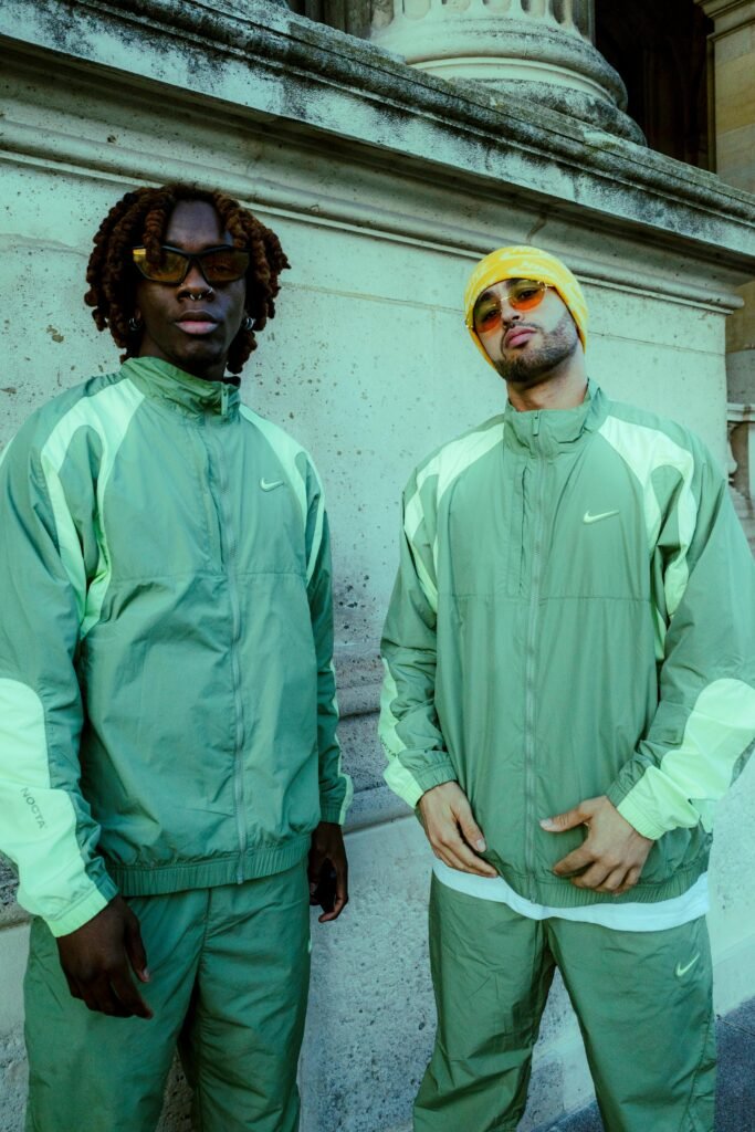 Two men in urban streetwear posing confidently outdoors.